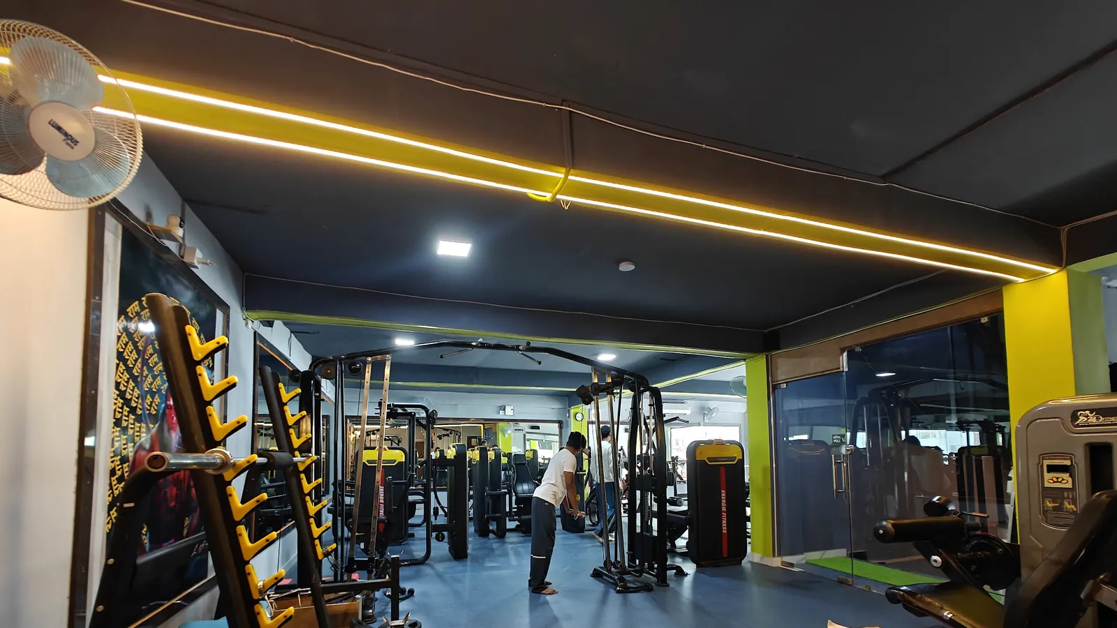 The renovated main floor at Gym-18 with new machines, a cable station and yellow LED lights