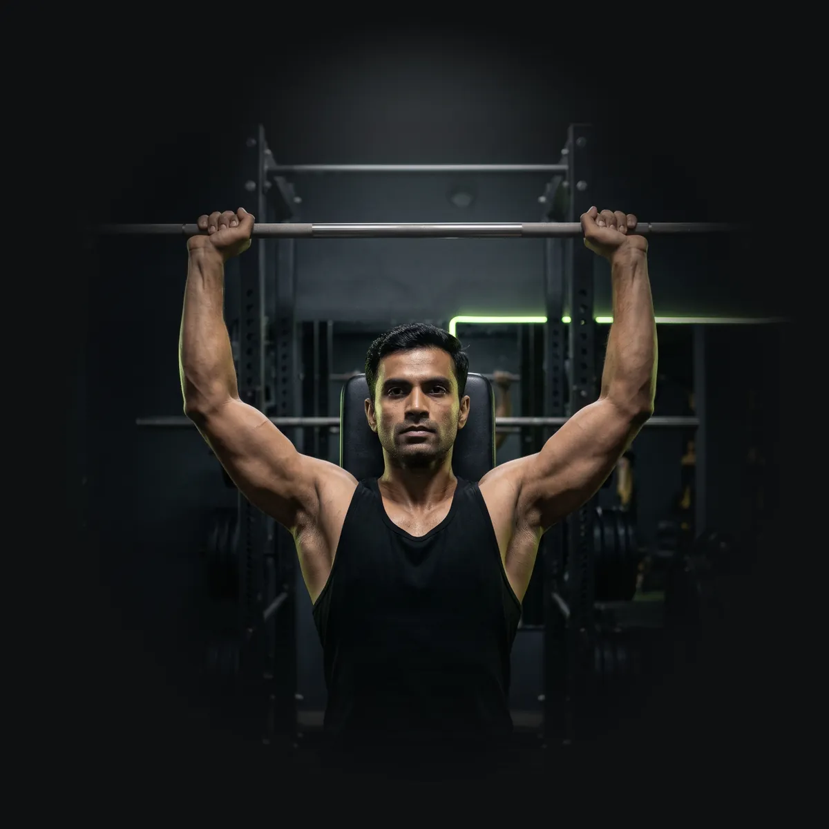 Man pressing a barbell overhead on a bench